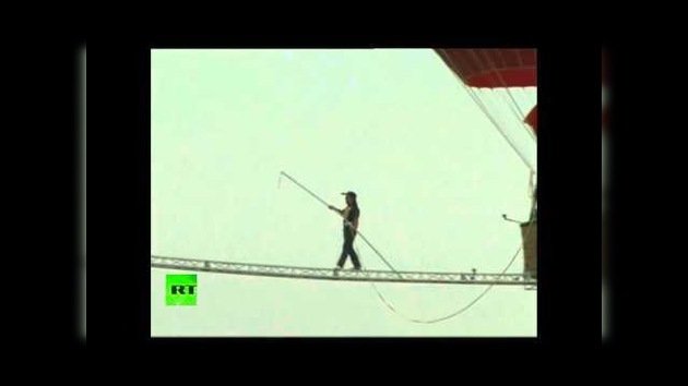 Un equilibrista chino cruza de un globo a otro por una delgada viga