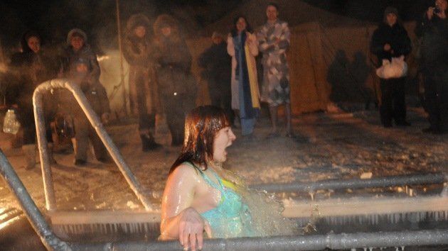 Rusos se bañan en agua helada en la fiesta de la Epifanía