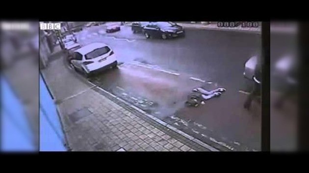 Policías arrastran a una mujer hacia el borde de la calzada y se van en un coche no identificado