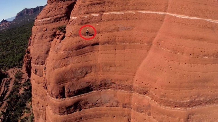 Un dron graba a un ciclista de montaña sobre un risco casi vertical 