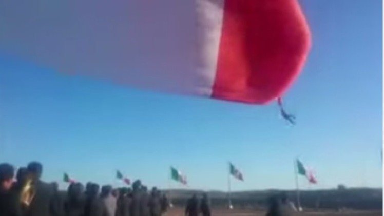 Un soldado vuela enredado en una bandera gigantesca de México
