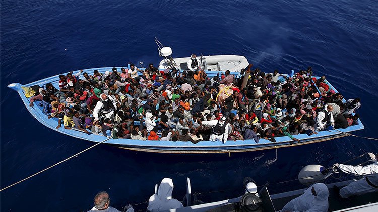Impactantes fotos de inmigrantes libios hacinados en un barco de madera