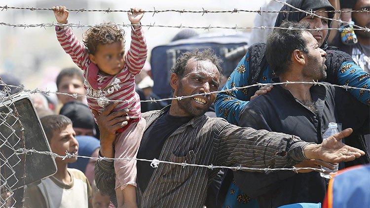 Foto conmovedora: Una niña siria y su padre huyen desesperados del Estado Islámico