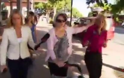 Una mujer apaga su cigarrillo en la cara de una reportera