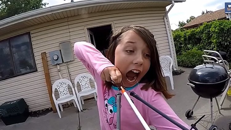Una niña osada se arranca un diente flojo atándolo a una flecha