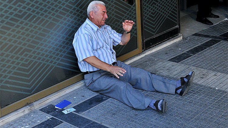 La foto que conmociona la Red: Un jubilado griego llora a las puertas de un banco