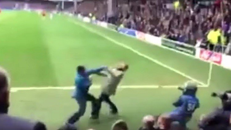 Dos hinchas de fútbol británicos saltan al campo en pleno partido para pelearse