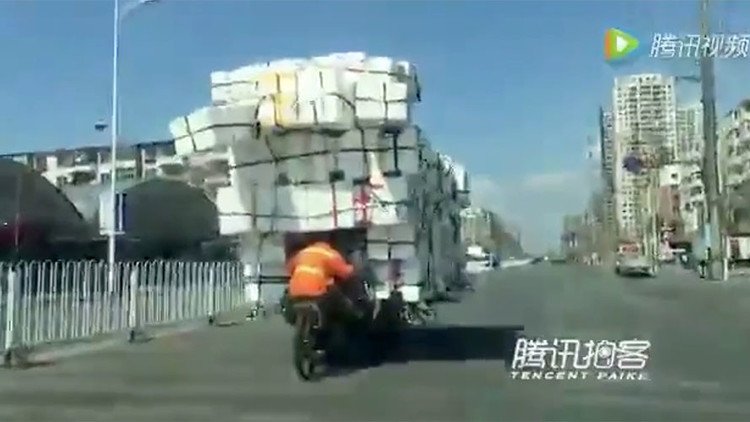 Un chino desafía la gravedad transportando una montaña de cajas en una pequeña moto