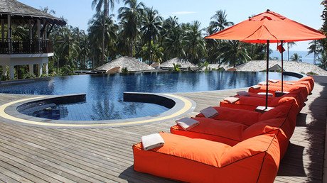 Una empleada de hotel se pasea con un rifle junto a la piscina y cunde el pánico