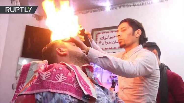 Este peluquero de Gaza les calienta la cabeza a sus clientes. Literalmente