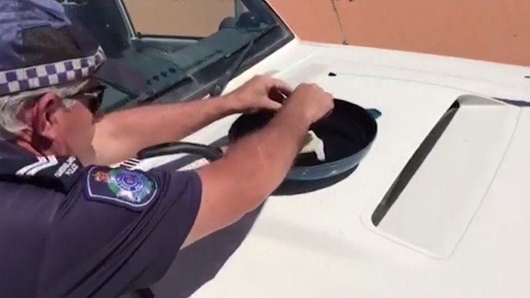 ¡Vaya calor hace en Australia! Un policía fríe un huevo sobre su coche