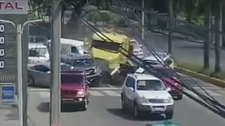 Un camión arrastra a varios vehículos y se estrella en una gasolinera