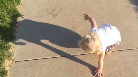 Una niña pequeña se enfada con su propia sombra