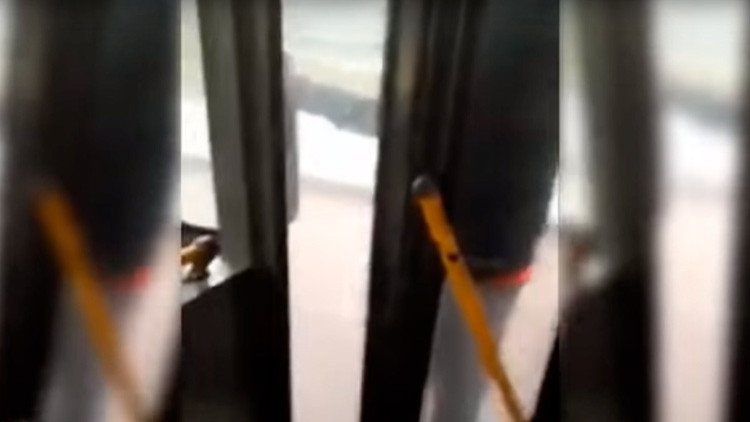 Un pasajero viaja colgado de la puerta de un ómnibus porque el chofer no quiere abrir (VIDEO)