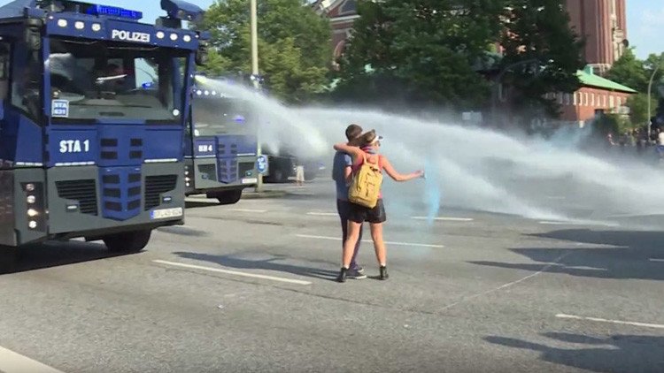 Beso anti-G20: un cañón de agua 'enfría' la pasión de una pareja en Hamburgo (VIDEO)