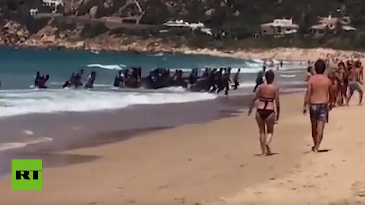 VIDEO: Una patera llena de inmigrantes llega a una playa de España ante el asombro de los bañistas 