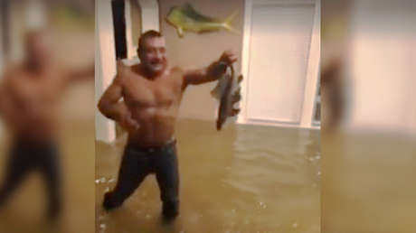 Un hombre captura un pez en su casa de Houston tras el paso del huracán Harvey