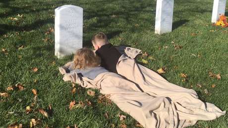Tiernas fotos de dos niños descansando sobre una tumba emocionan a las redes