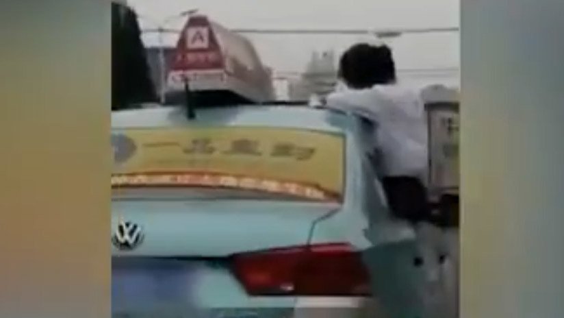 VIDEO: Una estudiante hace su tarea en el techo de un taxi en movimiento en China