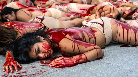FOTOS: Hombres y mujeres se desnudan y se cubren con sangre artificial en una zona comercial de España para protestar contra el uso de pieles