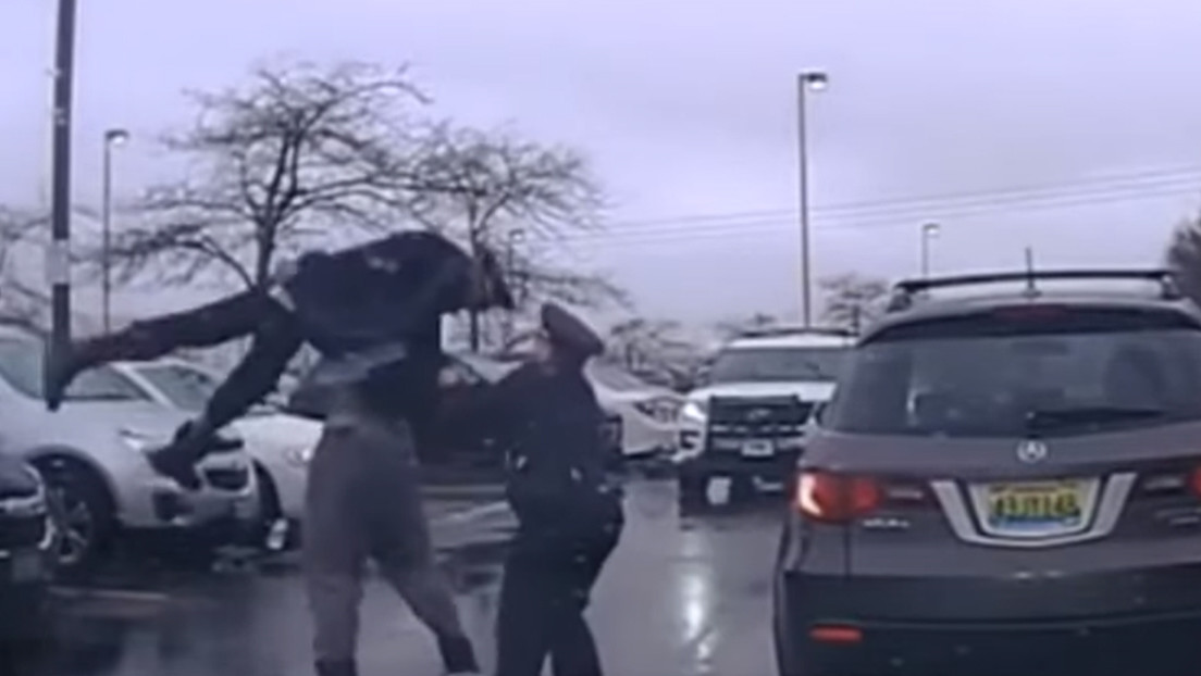 Momento en el que un jugador de fútbol americano levanta y arroja al suelo a un policía durante un enfrentamiento