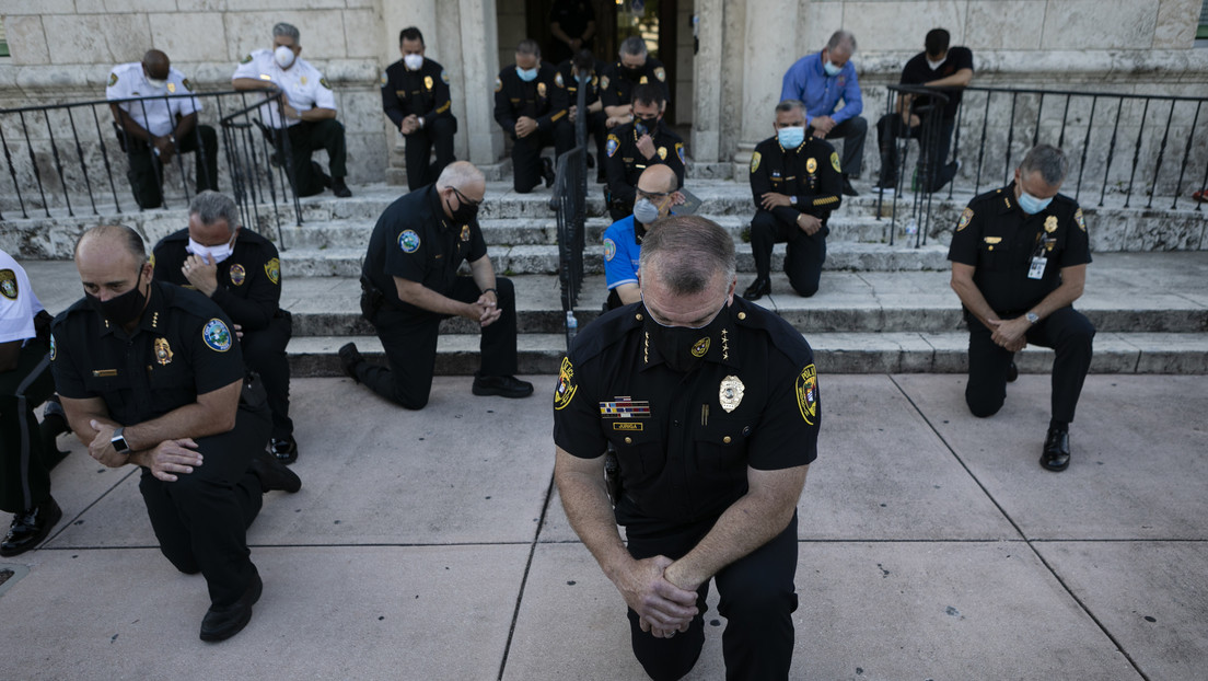 Oficiales rezan de rodillas en solidaridad con los manifestantes contra la brutalidad policial en Florida