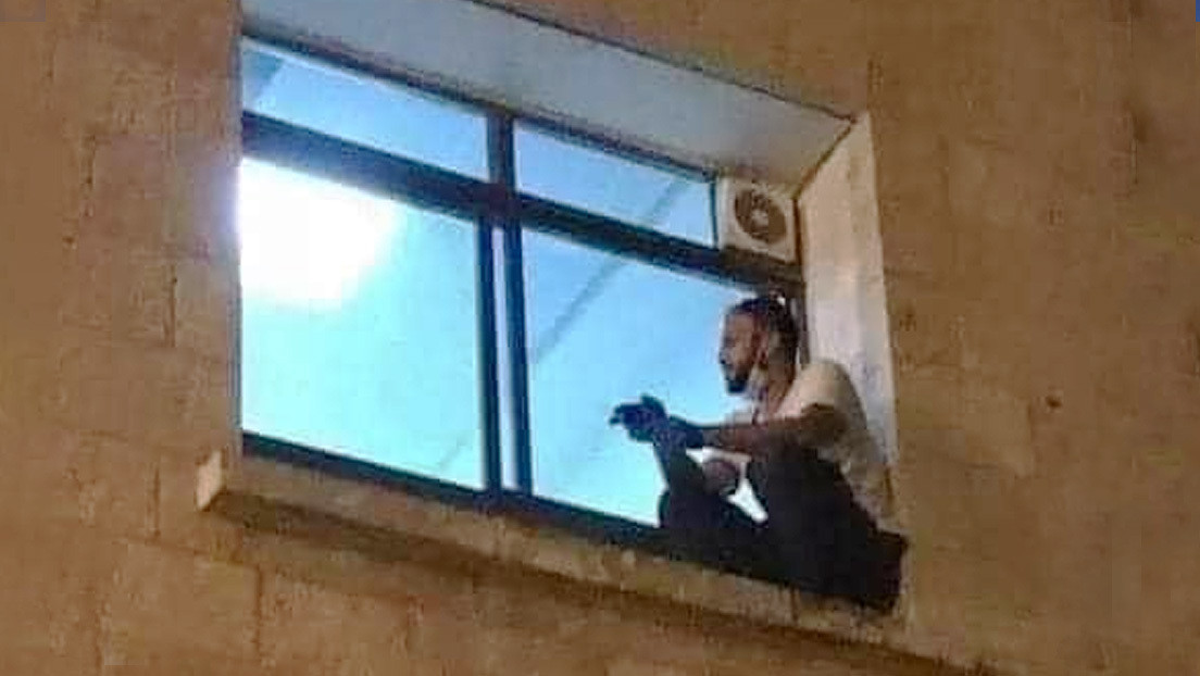 FOTO: Un hombre trepa la pared de un hospital para despedirse de  su madre antes de que fallezca por covid-19
