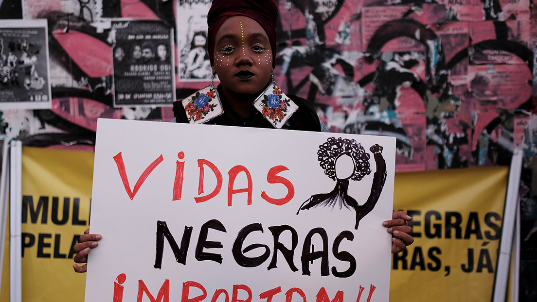 Demonstrator holds a sign reading "Black Lives Matter" while taking part in a protest by black women against racism and machismo in Sao Paulo