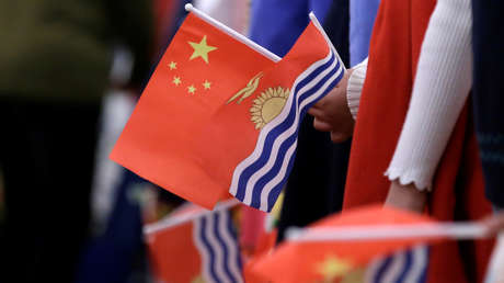 FOTO: El embajador de china en Kiribati camina sobre las espaldas de residentes al llegar a una isla del pequeño país