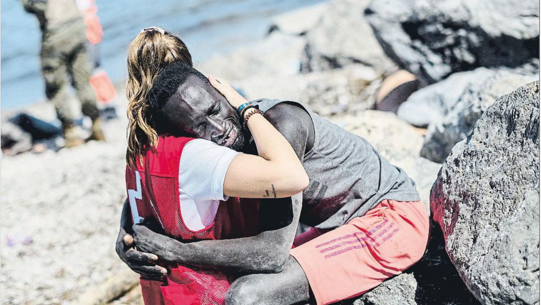 El abrazo que desató el odio y la solidaridad en España: una voluntaria de Cruz Roja consuela a un migrante que acaba de llegar a Ceuta