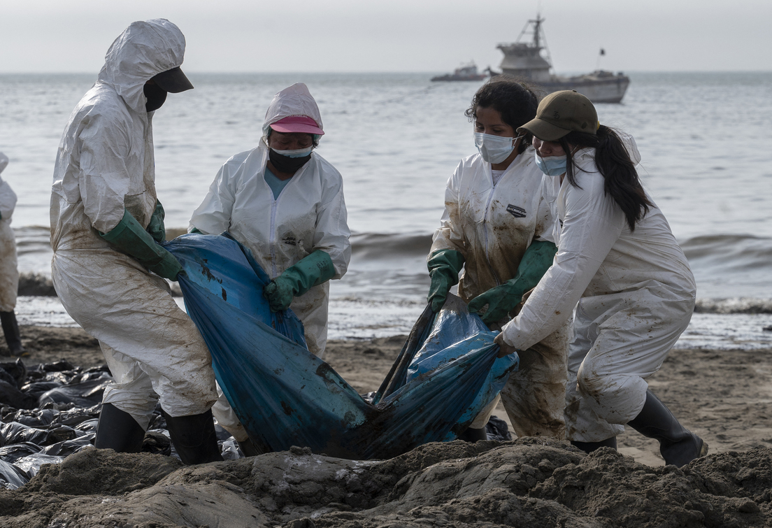 Equipos de limpieza trabajan para retirar petróleo de una playa anexa a Ancón, 20 de enero de 2022Cris Bouroncle / AFP