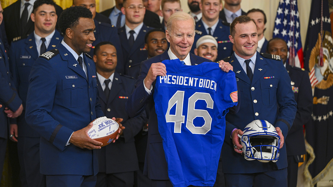 Deportistas le entregan a Biden un balón, un casco y una camiseta, pero se queda solo con un regalo (VIDEO)
