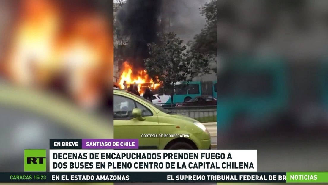 Decenas de encapuchados prenden fuego a dos buses en pleno centro de la capital chilena