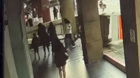 VIDEO: Transeúntes quedan en medio del impacto cuando un letrero se desploma