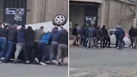 VIDEO: Vecinos se unen para poner 'en pie' un auto volcado en plena calle