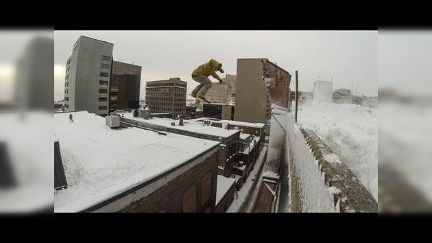Un snowboardista salta entre dos edificios