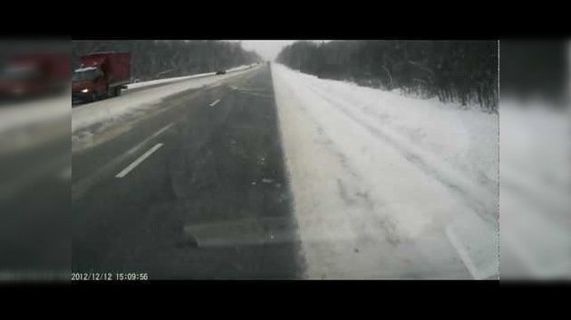 Un camión lleno de troncos patina en una carretera rusa y vuelca sin causar daños