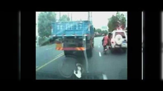 Ciclista china a punto de morir bajo las ruedas de un camión