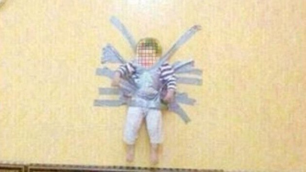 Una imagen muestra a un niño saudita pegado a la pared con cinta adhesiva