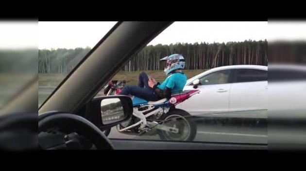 Maneja la moto sin manos en plena carretera