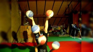 Una chica hace malabares con sus pies con cinco pelotas de baloncesto a la vez