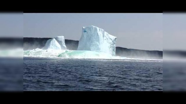 Un enorme iceberg se derrumba a poca distancia de unos turistas