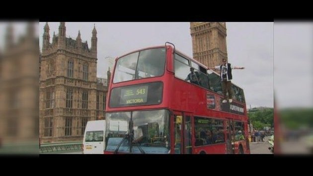 Ilusionista británico levita junto a típico autobús londinense
