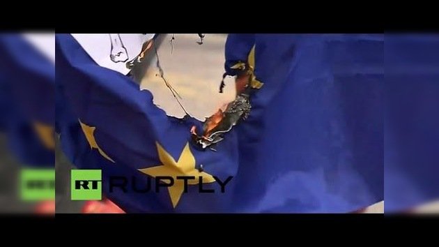 Agricultores españoles queman la bandera de la UE frente a montañas de fruta