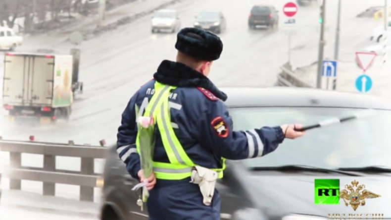 Russischer Verkehrs-Polizist winkt PKW-Fahrerin aus dem Verkehr. 