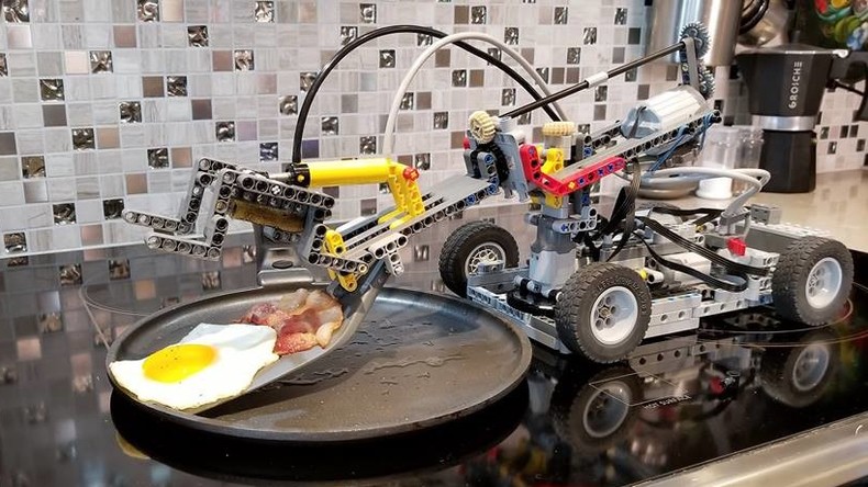 LEGO-Koch bereitet Standard-Frühstück aus Spiegelei und Bacon zu