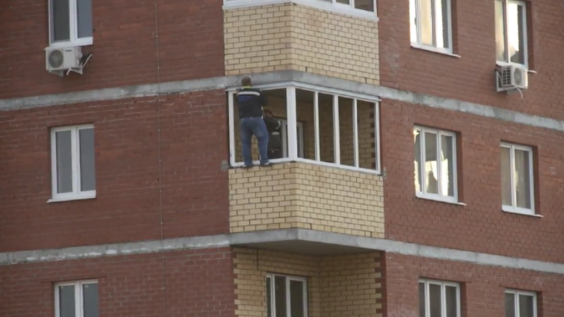 Ohne Sicherung im 12. Stockwerk: Russischer Fensterbauer werkt in schwindelerregender Höhe 