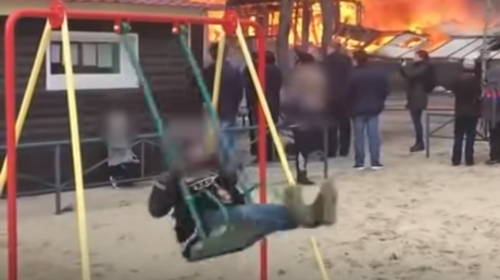Symbol der Unerschütterlichkeit: Junge tobt sich auf Schaukel vor loderndem Haus aus (Video)