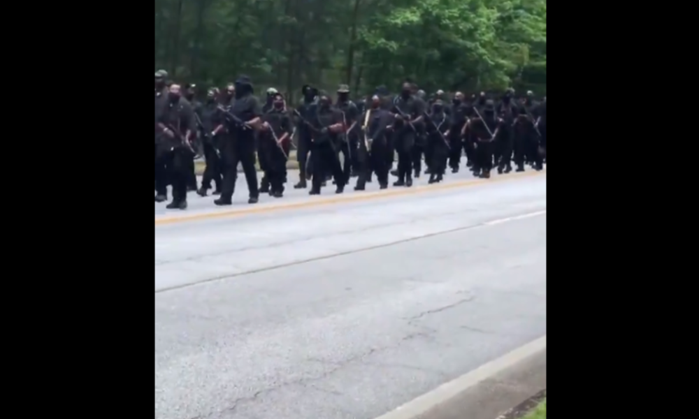Hunderte von schwer bewaffneten afroamerikanischen Demonstranten marschieren durch Georgia
