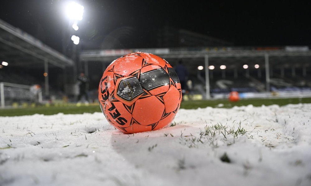 Weiß auf Weiß: Schnee auf Rasen macht Fußballspieler beinahe unsichtbar